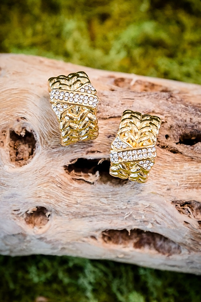 VEITA Jewelry gold chunky woven braided hoop earrings with pavé CZ stones displayed on driftwood with natural background