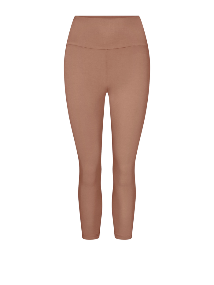 A pair of high-waisted, 3/4  length leggings in a solid warm tan shown on a plain white background.