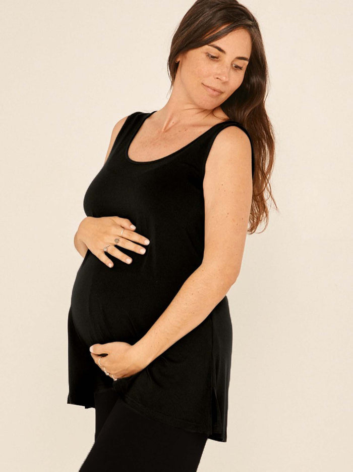 Model wearing a reversible black a-line singlet with scoop and boat necklines and long line body, women's bamboo clothing