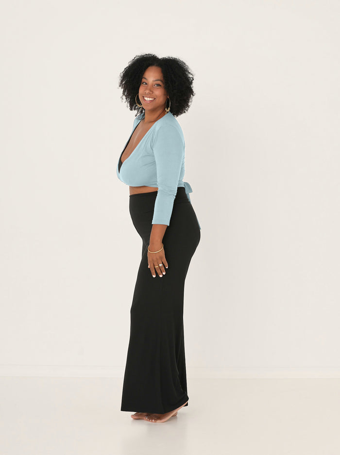 Woman wearing Bamboo light topaz blue wrap cardigan top with a tie detail and black wide leg palazzo pants on a white background