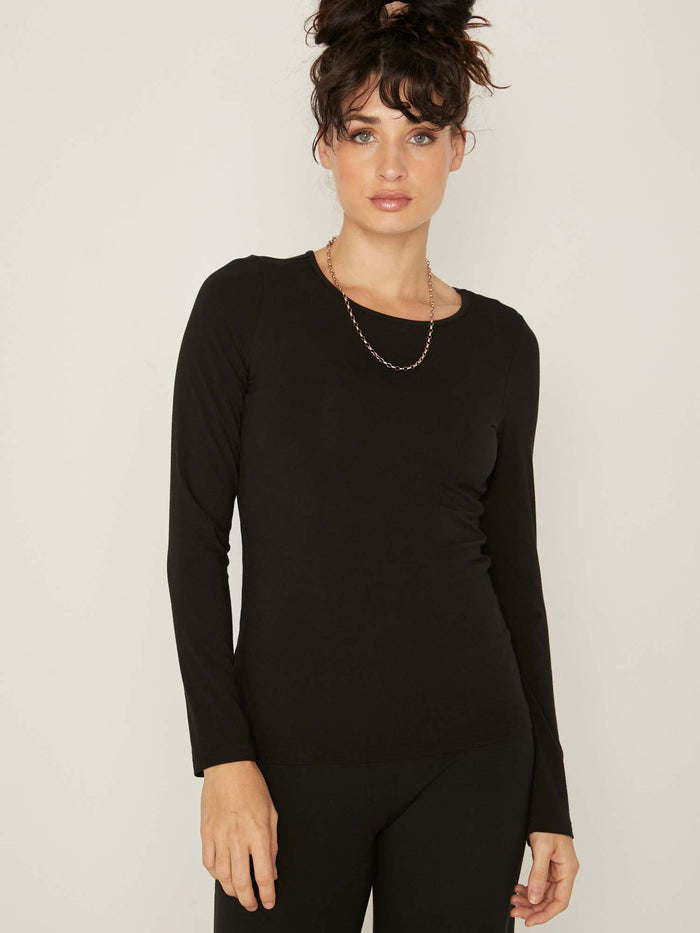 Model wearing a reversible black fitted body long sleeve t-shirt with crew and boat necklines, women's bamboo clothing