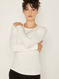 Model wearing a reversible cream fitted body long sleeve t-shirt with crew and boat necklines, women's bamboo clothing