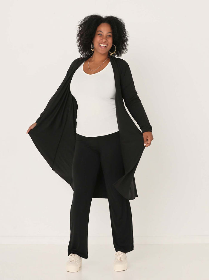Model wearing black long cardigan, below knee length jacket with long fitted sleeves, women's bamboo clothing