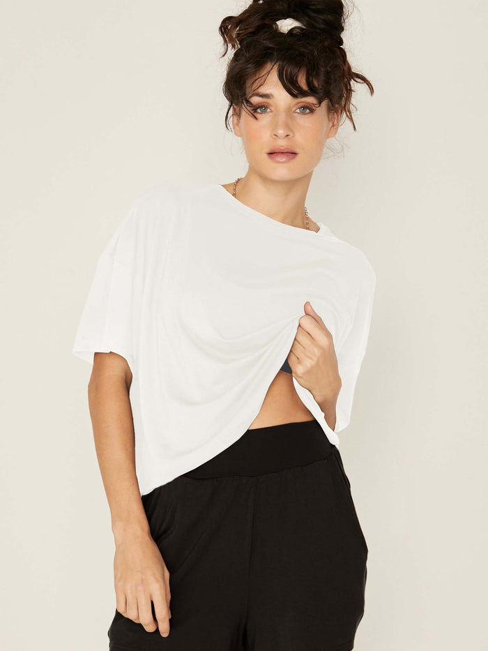 Model wearing a cream cropped boxy t-shirt, crew neckline, relaxed short sleeve and drop shoulder, women's bamboo clothing