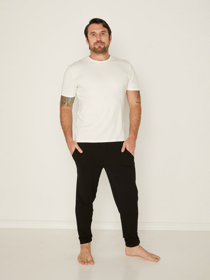 Male model wearing cream generous classic fit tee, soft neckband, crew neckline, short sleeve, men's bamboo clothing