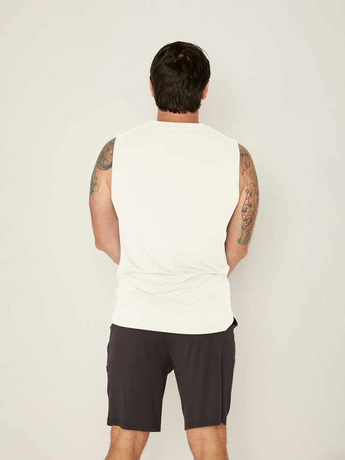 Male model wearing cream generous classic fit tank singlet, soft neckband, crew neckline, sleeveless, men's bamboo clothing