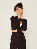Model wearing convertible black mid cardigan, worn tied at front or worn open with long fitted sleeves, women's bamboo clothing