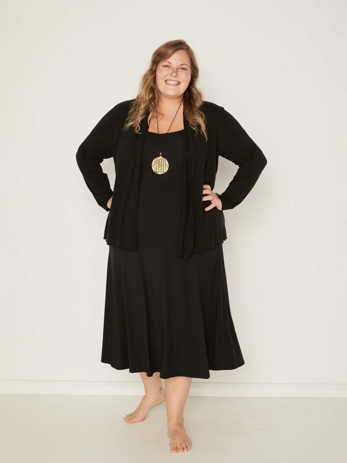 Model wearing convertible black mid cardigan, worn tied at front or worn open with long fitted sleeves, women's bamboo clothing