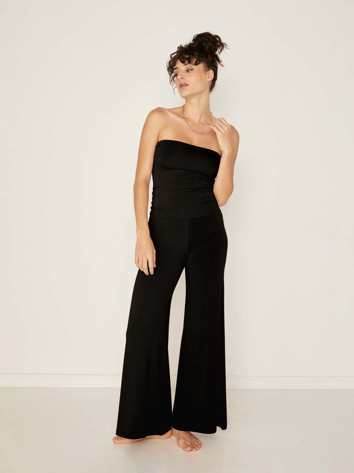 Model wearing black full length palazzo pants, fitted waist and hips with flowing wide leg, adjustable high waistband, women's bamboo clothing