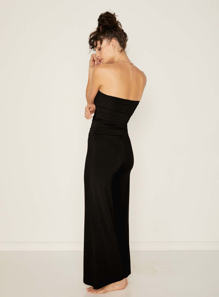 Model wearing black full length palazzo pants, fitted waist and hips with flowing wide leg, adjustable high waistband, women's bamboo clothing