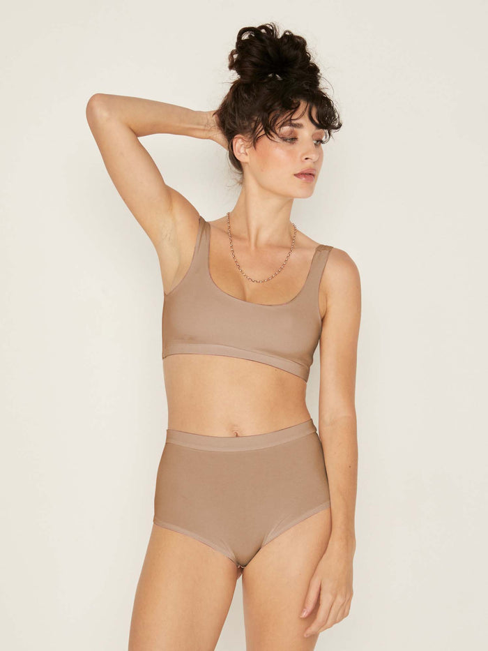 Model wearing caramel reversible bra, high or low scoop neckline and wide shoulder straps, wireless bra, women's bamboo underwear