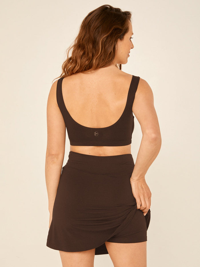 Model wearing a cocoa brown skort, a mid thigh length mini style skirt with hidden built in bike shorts and a hidden pocket, women's bamboo clothing