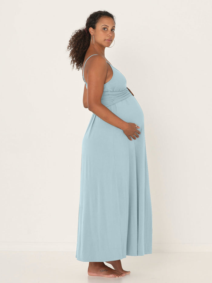 Pregnant woman wearing a light blue bamboo maxi slip dress against a white background