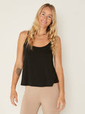 Model wearing a black swing style singlet with a scoop neck and elasticated camisole straps, women's bamboo clothing