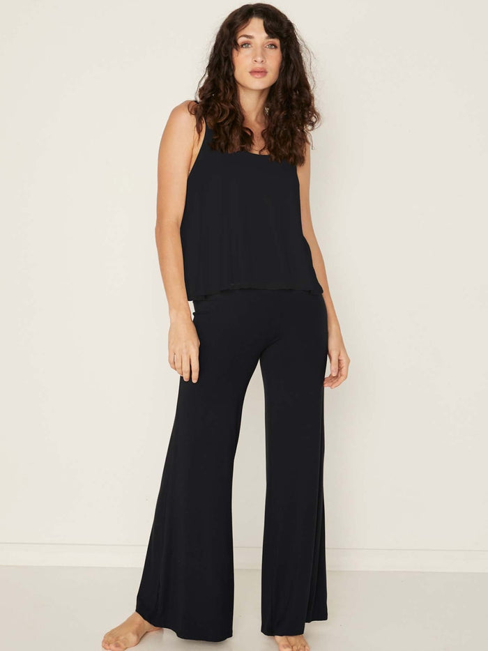 Model wearing a black swing style singlet with a scoop neck and elasticated camisole straps, women's bamboo clothing