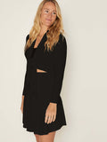 Model wearing black knee length swing style swishy mini skirt with adjustable high waistband, women's bamboo clothing