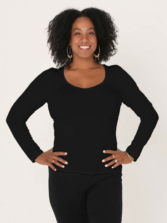 Model wearing a reversible black fitted body, long sleeve t-shirt with v and boat necklines, women's bamboo clothing