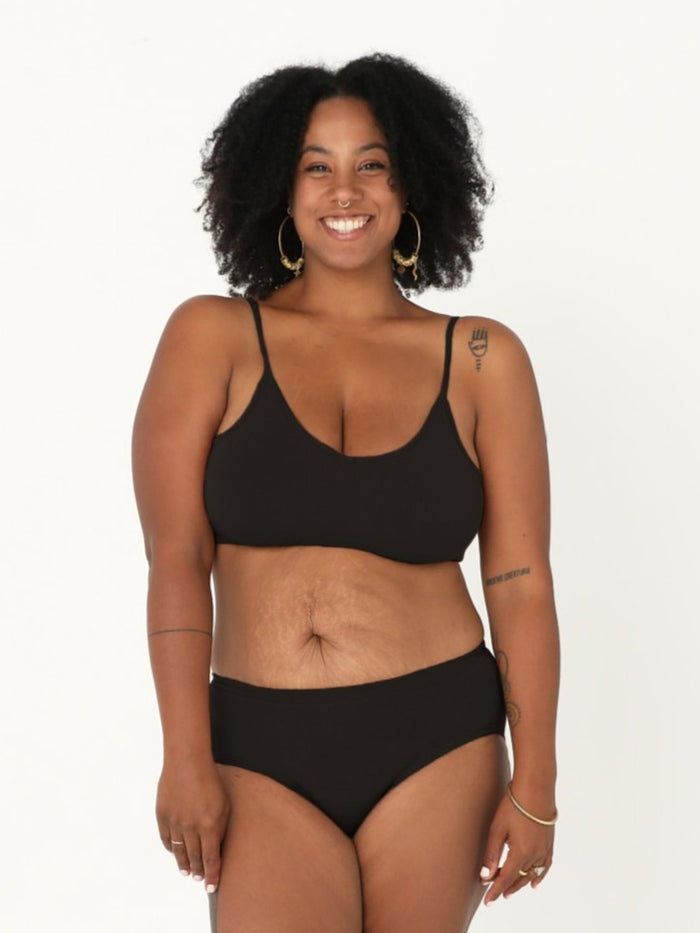 Model wearing a black wireless yoga bra, subtle v front, soft cup bralette with adjustable camisole straps, women's bamboo underwear