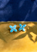 Turquoise butterfly earrings on a gold and blue background