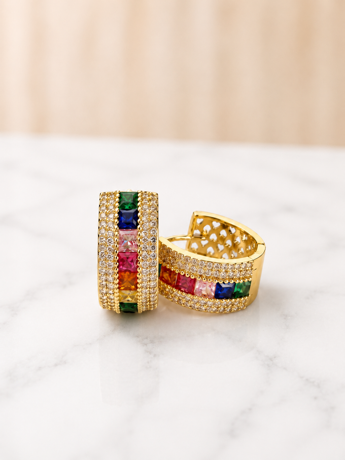 Declan Hoops in gold with multicolor gemstone and diamond pavé detailing on marble surface