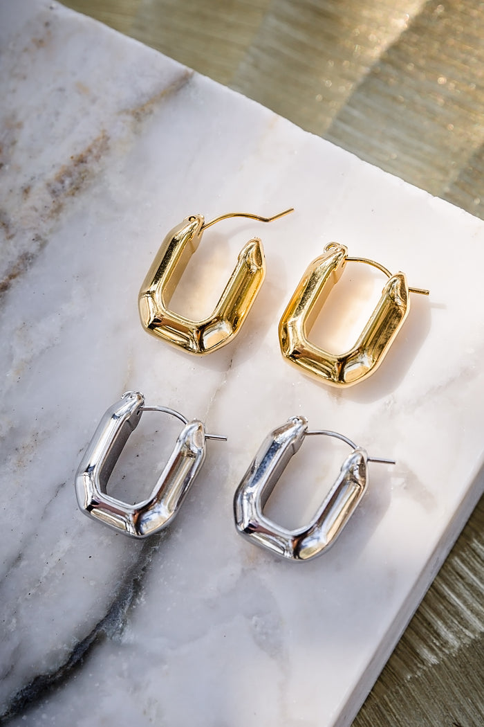 Echo hoop earrings featuring sculptural rectangular design in gold and silver metal options with a modern minimalist look