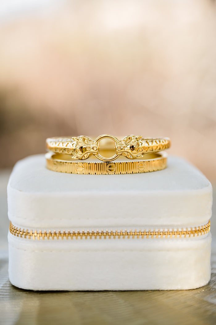 Close-up of Feline bangle (top) and Vesper textured gold bangle showing detailed finish, hinged closure, and polished 18kt gold plating
