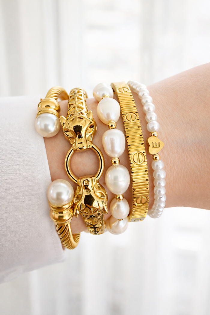 Feline Bangle (2nd from left) Vesper (4th from left) textured gold bangle styled in a stacked wrist look with other bracelets, showcasing everyday wear and layering