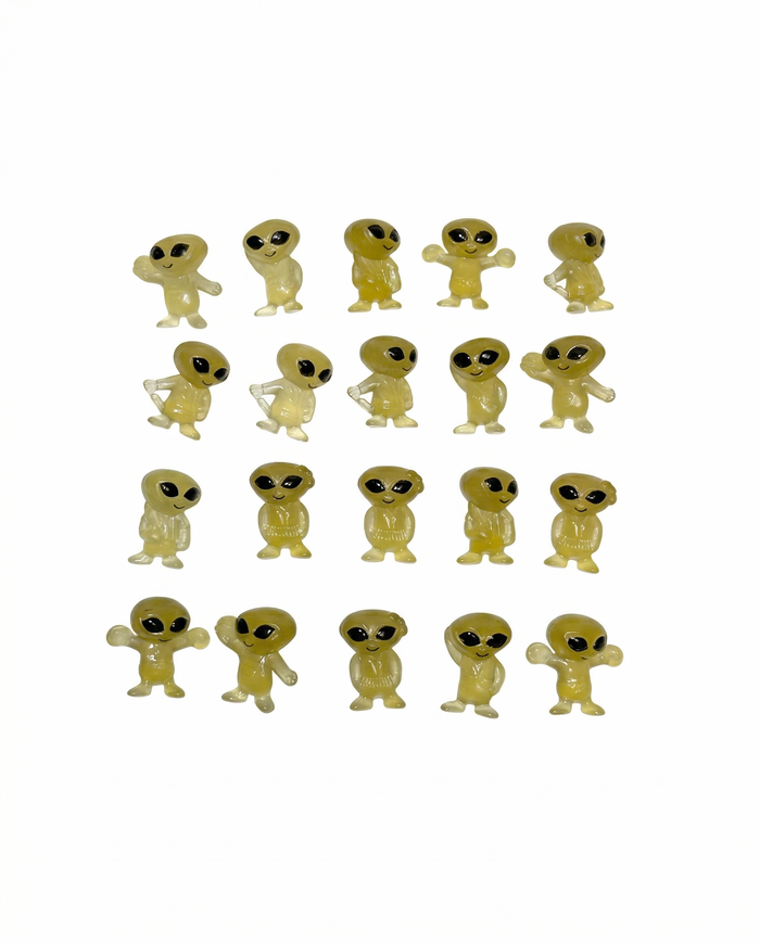 Set of small yellow alien figurines on a white background