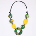 Necklace with green, yellow, and black circular beads on a white background