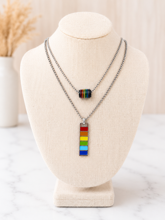Harvey Barrel Necklace with Pride rainbow striped rectangular pendant necklace on a silver chain displayed on a linen jewelry bust