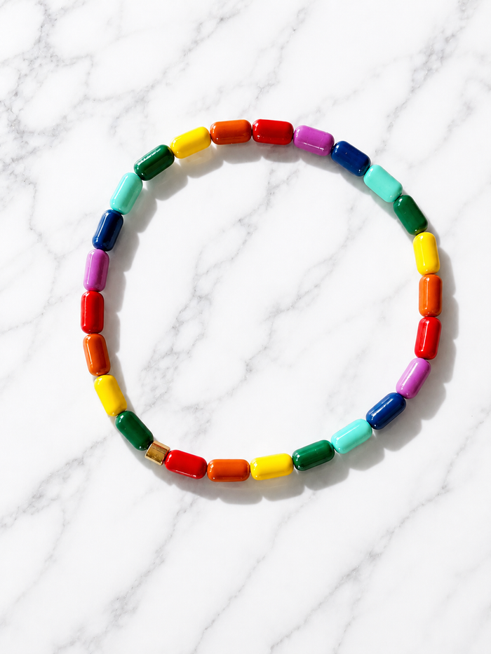 Iris Beaded Bracelet with large multicolor barrel beads arranged in a circle on a marble surface