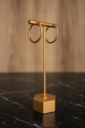 Lupita Hoops featuring twisted gold hoop earrings crafted from stainless steel with 18kt gold plating displayed on a jewelry stand.