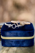 Panther head bangle bracelet with pavé stones displayed on blue velvet jewelry box