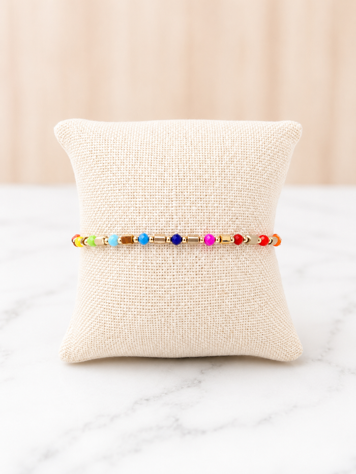 Prism Adjustable Bracelet with multicolor beads and gold chain on a linen jewelry pillow