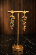 Raelynn gemstone cascade earrings featuring colorful natural gemstones and 18kt gold-plated shell posts displayed on a gold jewelry stand.