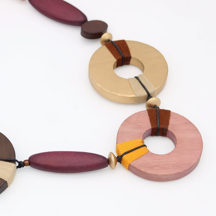 Colorful wooden necklace with circular and oval beads on a white background