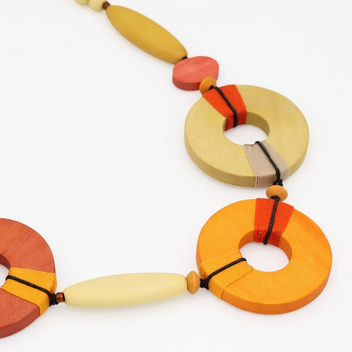 Colorful necklace with wooden rings and beads on a white background