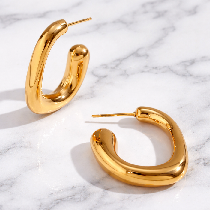 Gold sculptural hoop earrings with size and measurement details shown