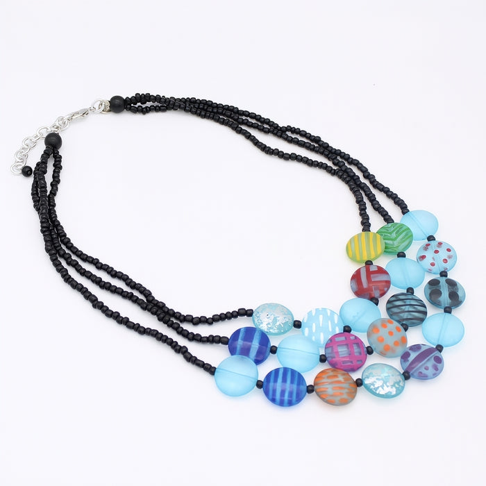 Necklace with black beads and colorful patterned beads on a white background