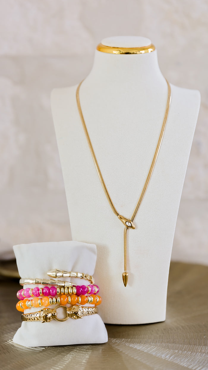 Serpentine necklace worn on jewelry display bust styled with colorful bracelets
