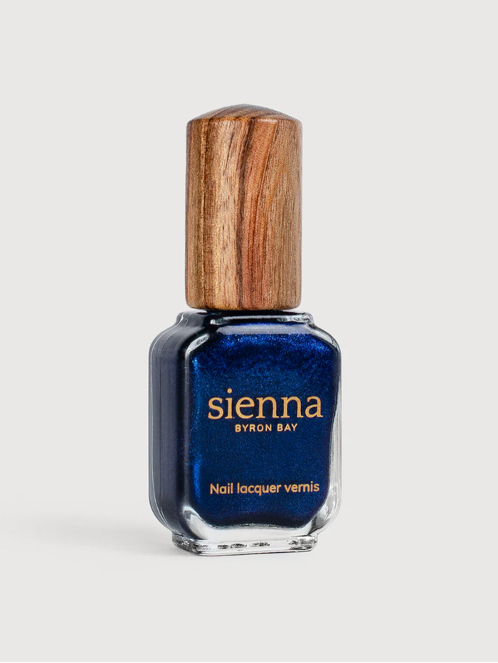 Blue nail polish bottle with wooden cap on a white background