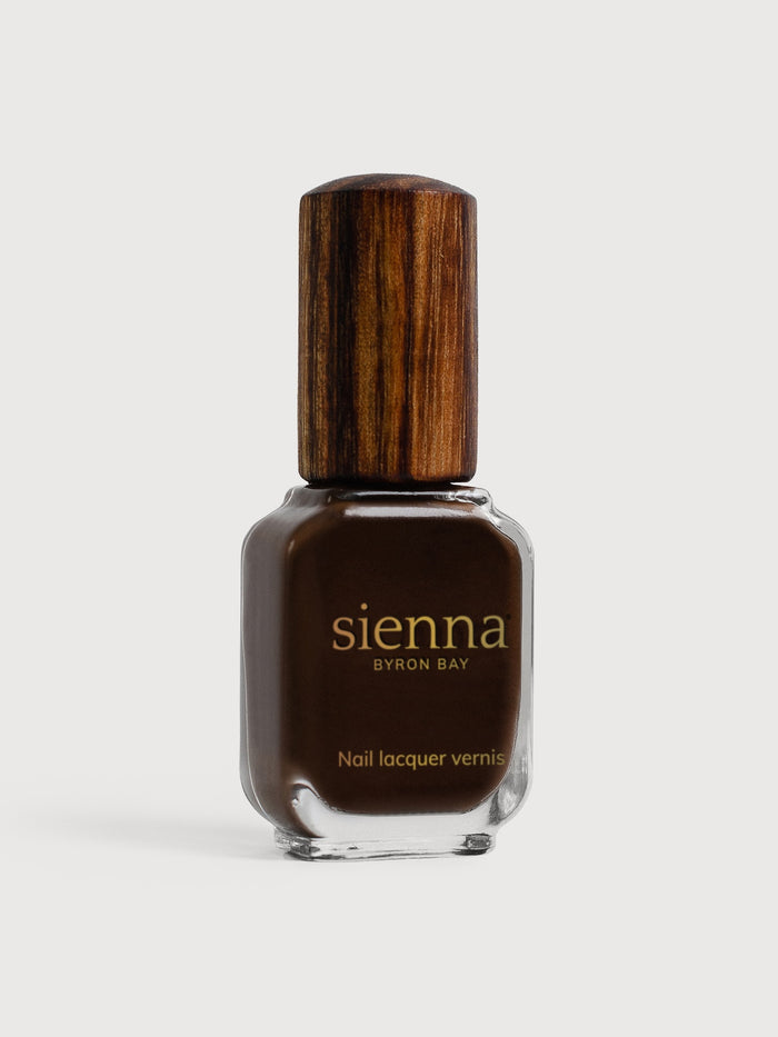 Brown nail polish bottle with wooden cap on a white background