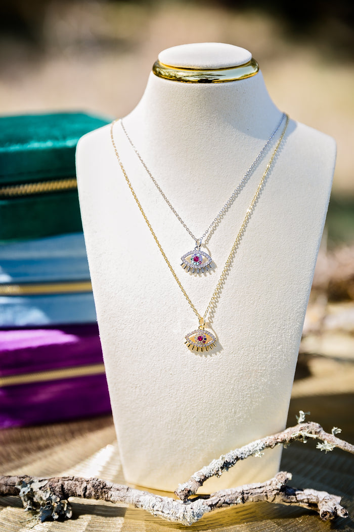 Spectral eye necklace featuring gold and silver evil eye pendants with multicolor zircon stones displayed in layered styling