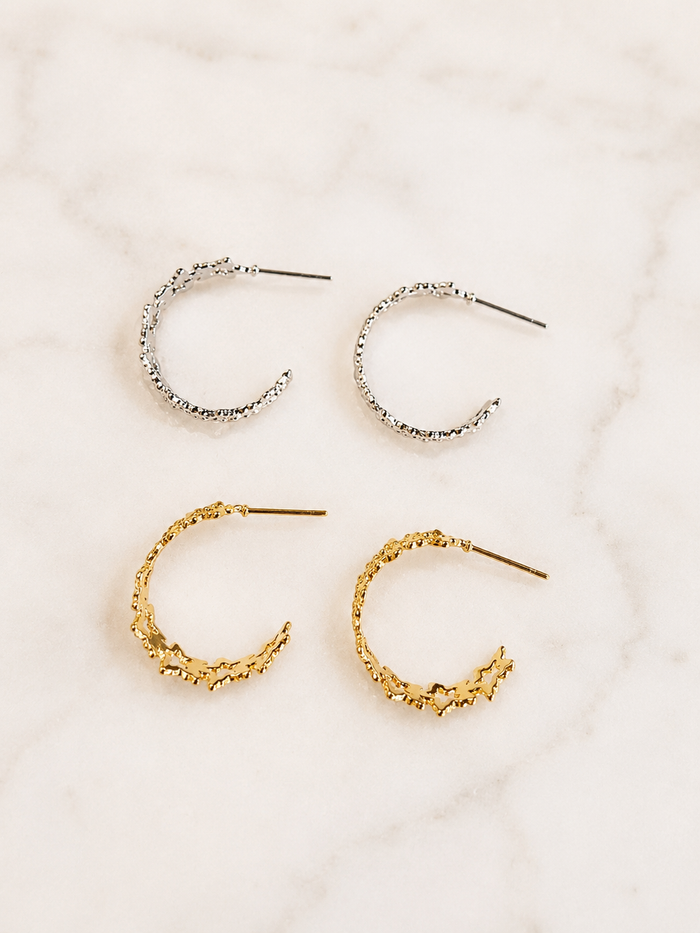 Textured Star Hoops in gold and silver finishes featuring textured star details displayed on a marble surface.