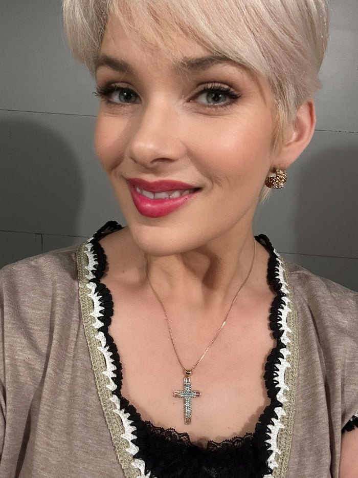 Model wearing VEITA Jewelry crystal cross pendant necklace and gold dome stud earring