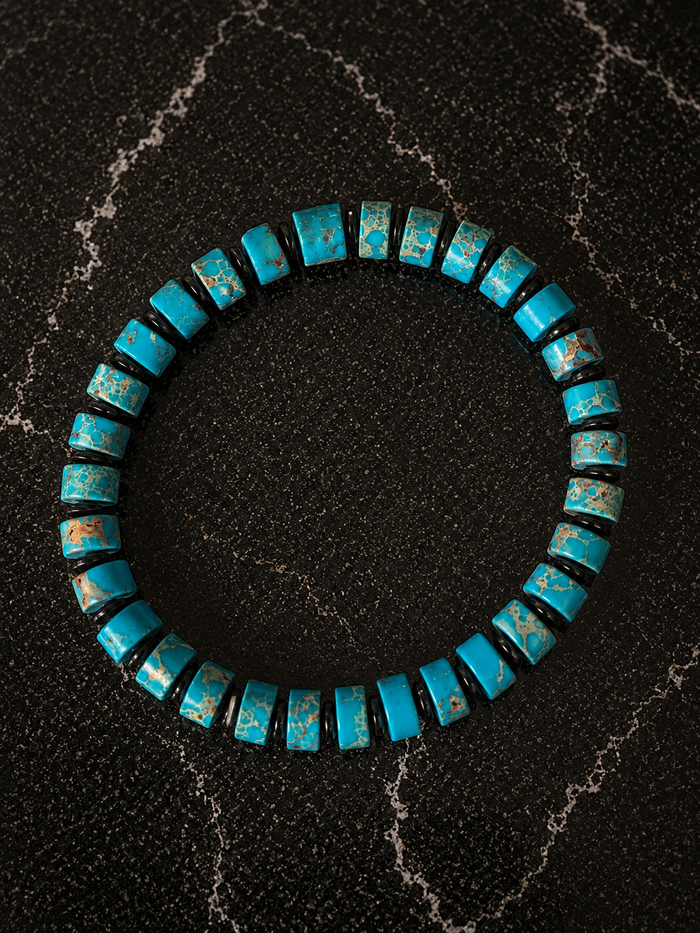 Wayfinder bracelet with turquoise gemstone beads and hematite accents on a stretch band.