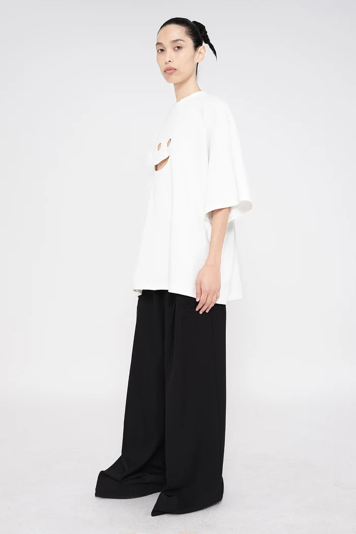 PERSON-WEARING-WHITE-TEE-WITH-SMILEY-FACE-CUT-OUT-AND-BLACK--TAILORED-PANTS-THREE-QUARTER-VIEW