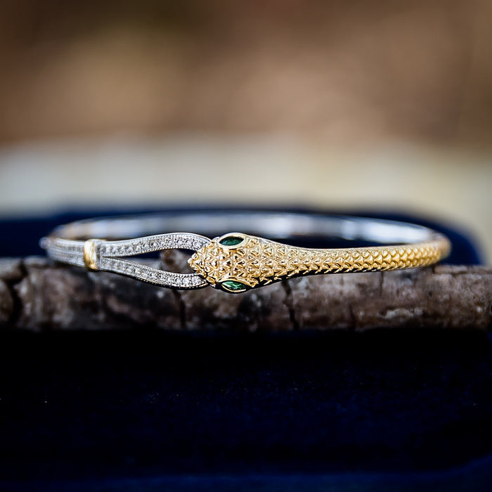 Wild Asp snake bangle bracelet featuring gold and silver tones, green zircon stone eyes, and 18kt gold plated hinged design