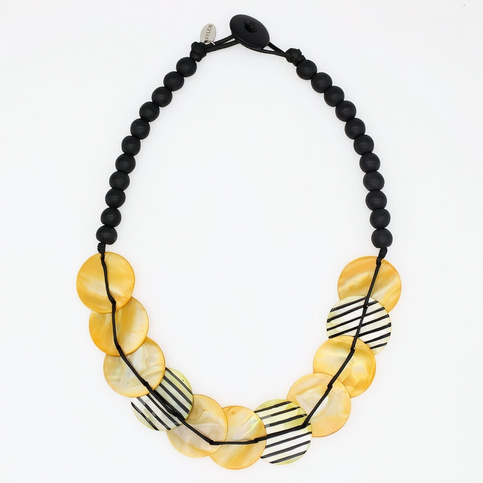 Necklace with yellow beads and black and white striped accents on a white background