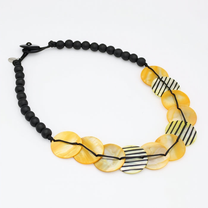 Necklace with yellow circular beads and black beaded chain on a white background